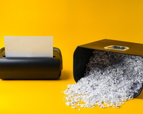 Office paper shredder on yellow studio background