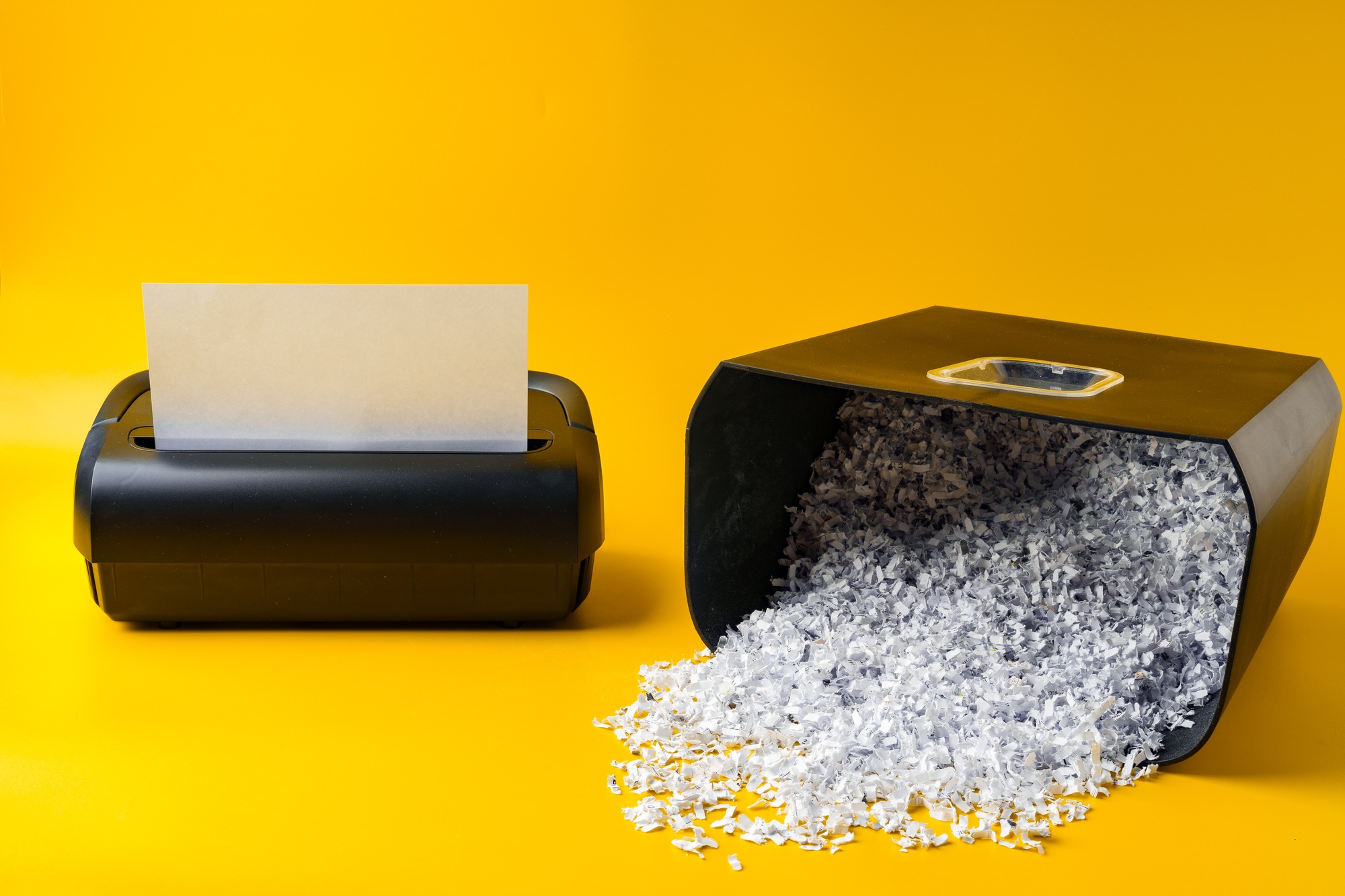 Office paper shredder on yellow studio background